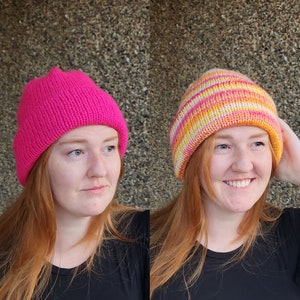 May include: Two women wearing different knitted hats. One hat is a solid pink color, and the other is a striped hat with pink, orange, and white stripes.