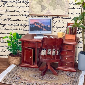 Puede incluir: Escritorio de madera en miniatura con ordenador, silla y accesorios. El escritorio es de color marrón oscuro con cajones y una pequeña puerta abierta. Una pequeña alfombra y plantas en macetas completan la escena. Un mapa del mundo está en la pared.