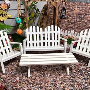 Peut inclure: Ensemble de mobilier de jardin en bois blanc de style cl&ocirc;ture &agrave; piquets. Il comprend un banc, deux chaises et une table basse. Le mobilier est en bois peint en blanc et a un charme rustique.