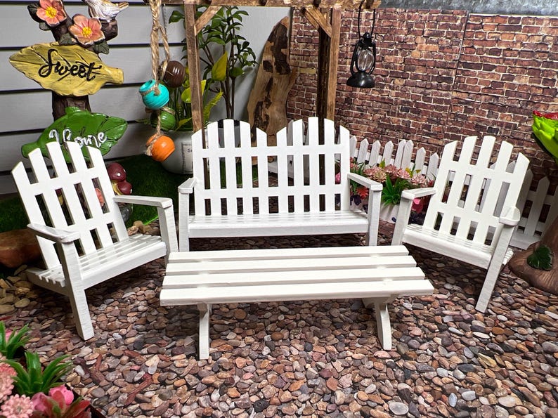 Peut inclure: Ensemble de mobilier de jardin en bois blanc de style cl&ocirc;ture &agrave; piquets. Il comprend un banc, deux chaises et une table basse. Le mobilier est en bois peint en blanc et a un charme rustique.