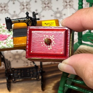 This adorable redwood color vintage needlework sewing kit is for 1/12 scale dollhouses. It has needles, threads, measuring tape, and cover. The front has painted perfect detailed golden flowers. It is so realistic and perfectly made.
