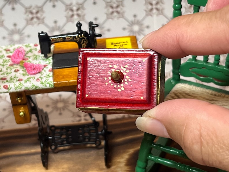 This adorable redwood color vintage needlework sewing kit is for 1/12 scale dollhouses. It has needles, threads, measuring tape, and cover. The front has painted perfect detailed golden flowers. It is so realistic and perfectly made.