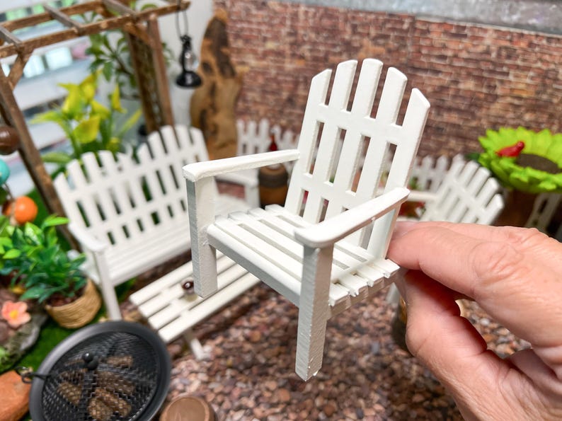 Peut inclure: Chaise longue en bois blanc avec un dossier et un si&egrave;ge &agrave; lattes. La chaise est faite de meubles miniatures pour une maison de poup&eacute;e ou un jardin de f&eacute;es.