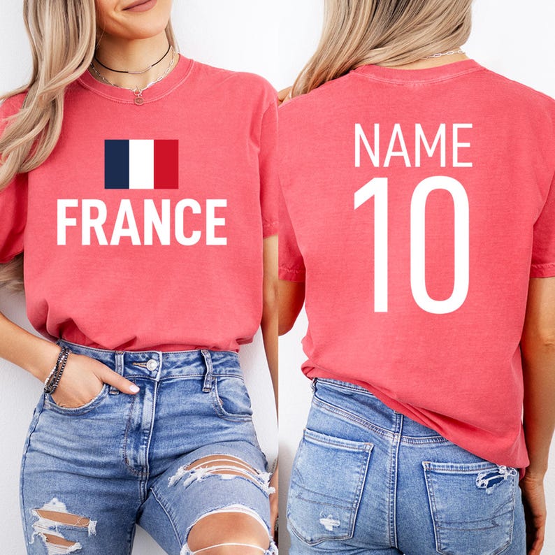 May include: Red t-shirt featuring the word "FRANCE" in white capital letters and the French flag on the front. The back of the shirt displays "NAME" above the number "10" in white.