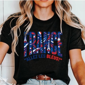 May include: Black t-shirt with the word "FRANCE" in blue and red, filled with French flag and landmark graphics. Below, the phrase "ALLEZ LES BLEUS!" is printed in blue and red.