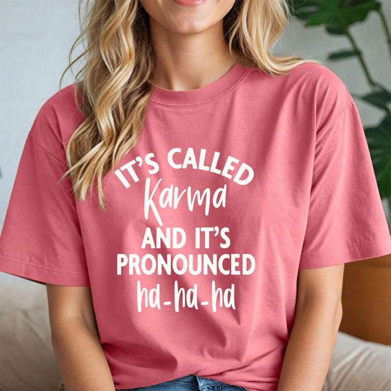 May include: A pink t-shirt with white text that reads "It's called Karma and it's pronounced ha-ha-ha."