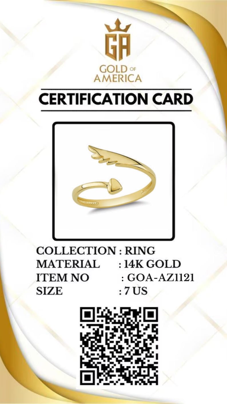 May include: A gold ring with an arrow and wing design, size 7 US, displayed on a certification card. The card includes the text "GOLD OF AMERICA" and "CERTIFICATION CARD". The ring is made of 14K gold.
