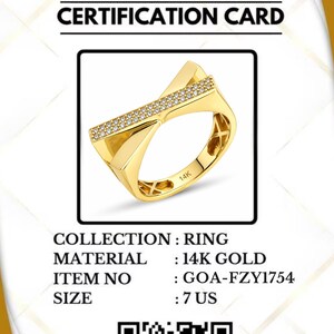 May include: A gold ring with a geometric design, featuring a row of small, sparkling stones. The ring is on a certification card from Gold of America. The size is 7 US.