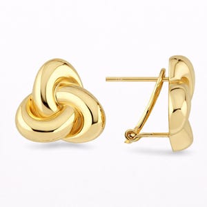 Pode incluir: Um par de brincos dourados com nós. Os brincos têm uma superfície polida e reflexiva e um fecho de pino e clip. O design apresenta uma forma de nó tridimensional, com cada laço suavemente conectado.