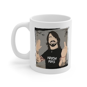 May include: White ceramic coffee mug with a grunge-style graphic of a man with long hair and a beard wearing a black t-shirt with the text "FRESH POTS" printed on it. The man is giving the middle finger and a peace sign.