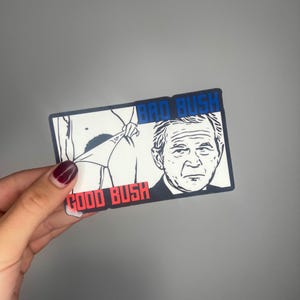 May include: A black and white sticker with a cartoon image of a person pulling down their trousers with the text "Bad Bush" above and "Good Bush" below.