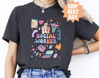 Könnte beinhalten: Ein dunkelgraues T-Shirt mit einem bunten Grafikdesign, das einen Laptop, ein Telefon und den Text "Sozialarbeiter" zeigt.