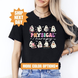 Puede incluir: Camiseta negra con un gráfico de fantasmas vestidos como fisioterapeutas. El texto "PHYSICAL therapy" está escrito en colores arcoíris.