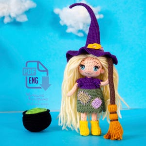 May include: Crochet amigurumi witch doll with long blonde hair, wearing a purple hat and dress, holding a brown broom. The doll is standing on a blue surface. PDF ENG.
