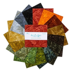 May include: A collection of hand-dyed fabric squares in various colors, including red, orange, green, and black. The fabric has a textured appearance and is arranged in a circular pattern. The label reads "hand-dyes Woodland Elegance."