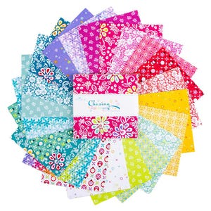 May include: A stack of square fabric swatches arranged in a circular fan pattern, featuring various floral and geometric prints in shades of pink, yellow, green, teal, and purple. A white paper band wraps the center with the text Chasing Rainbows.