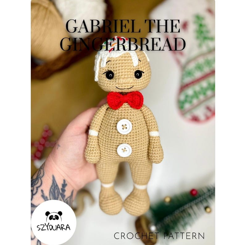 May include: A crocheted gingerbread man with a red bow tie, white icing details, and button accents. The text "GABRIEL THE GINGERBREAD" is displayed above the figure. The bottom of the image reads "CROCHET PATTERN".