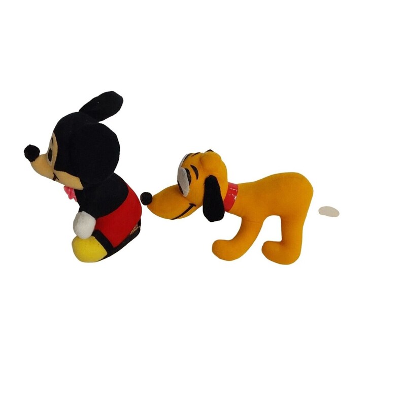 Op de afbeelding: Twee pluche Disney-personages, Mickey Mouse en Pluto, worden getoond tegen een witte achtergrond. Mickey Mouse draagt zijn klassieke outfit en Pluto is een gele hond met een rode halsband. Het speelgoed is zacht en lijkt goed gemaakt.