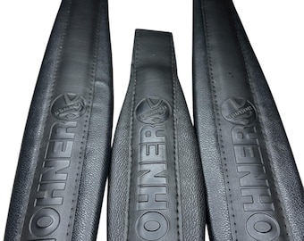 Peut inclure: Trois bretelles d'accordéon noires avec une surface texturée et des bords cousus. Chaque bretelle est gaufrée avec le logo HOHNER et le nom de la marque à la verticale. Les bretelles comprennent des boucles en plastique noir réglables.