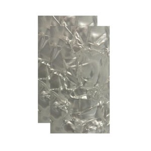 May include: Two sheets of white pearlescent guitar pickguard material with a cracked ice pattern.