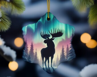 Könnte beinhalten: Sternförmiger Weihnachtsschmuck mit einer Elchsilhouette vor dem Hintergrund eines farbenfrohen Nordlichts und eines Waldes. Der Schmuck wird an einem goldenen Faden aufgehängt, mit einem verschwommenen Hintergrund aus Weihnachtslichtern und Tannennadeln.