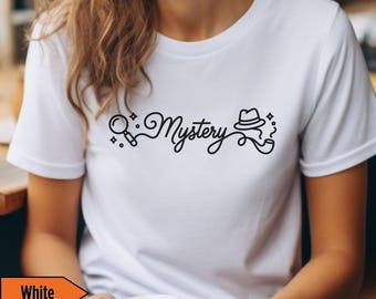 May include: White t-shirt with a black graphic that reads "Mystery" in a cursive font, accompanied by a magnifying glass, a hat, and a pipe. The shirt is plain and has short sleeves.