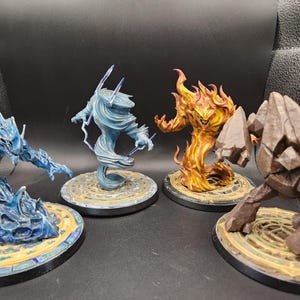 May include: Four fantasy figurines representing the elements: water, air, fire, and earth. The water figure is blue, the air figure is light blue with lightning, the fire figure is orange and yellow, and the earth figure is brown.