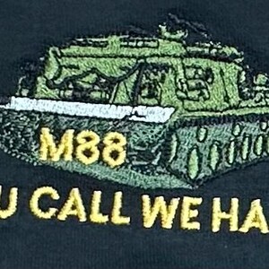 May include: An embroidered patch on a dark fabric featuring a green M88 tank with a white barrel. The text M88 appears in yellow above the tank, and the yellow text YOU CALL WE HAUL is embroidered in a bold font directly underneath the tank graphic.
