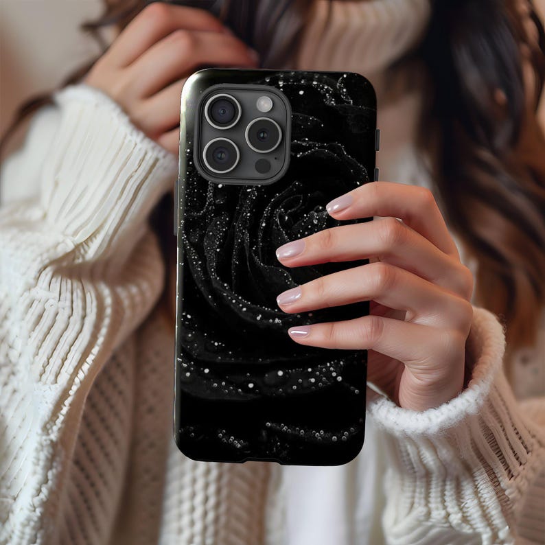 a woman holding up a black phone case