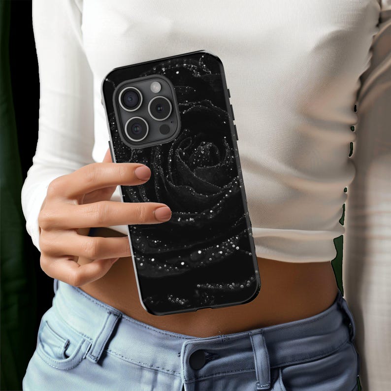 a woman holding a phone case with a picture of a rose on it