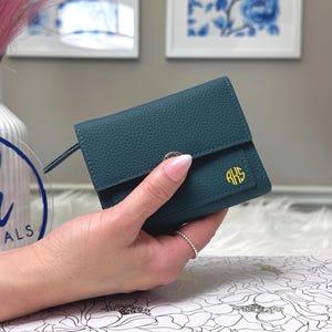 Puede incluir: Una taza de cerámica blanca con un asa negra y el texto "But First, Coffee" en negro, con una fuente de estilo manuscrito. La taza está sobre una superficie blanca.