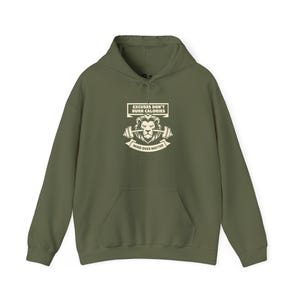 Puede incluir: Sudadera con capucha verde oliva con bolsillo delantero. El gráfico frontal presenta un león con una barra y el texto "EXCUSES DON'T BURN CALORIES" y "MIND OVER MATTER" en blanco.