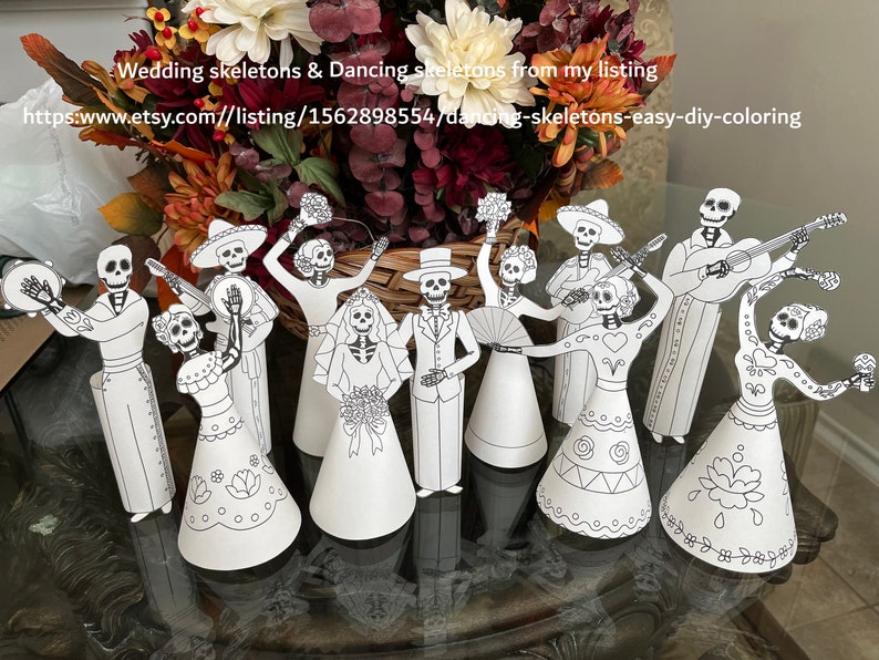 May include: A set of nine paper cut-out skeletons dressed in traditional Mexican wedding and party attire. The skeletons are ready to be coloured. The skeletons are holding musical instruments, flowers, and a fan. The text on the image reads "Wedding skeletons & Dancing skeletons from my listing https://www.etsy.com/listing/1562898554/dancing-skeletons-easy-diy-coloring"