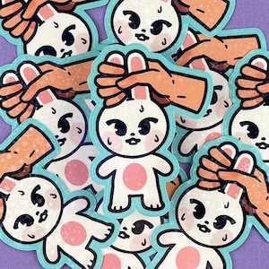 May include: A set of 10 colorful stickers featuring cartoon bunnies with outstretched arms. Each bunny has a different expression and is wearing a pink shirt. The stickers are perfect for adding a touch of whimsy to laptops, water bottles, or journals.