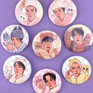 Op de afbeelding: Een verzameling van zeven ronde buttonspins met illustraties van mensen met cartoon-dierlijke metgezellen. De buttons hebben een roze, blauw en wit kleurenschema. De illustraties zijn in cartoonstijl.