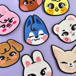 Peut inclure: Un ensemble de dix patchs brodés à repasser représentant différents animaux de dessin animé avec des expressions différentes. Les patchs sont de différentes couleurs, notamment le bleu, le rose, le marron, le blanc et le jaune.