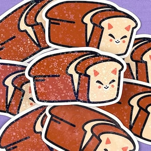 May include: A set of nine stickers featuring cartoon bread with cute faces. The bread is brown and has a sparkly texture. Each sticker has a different expression.