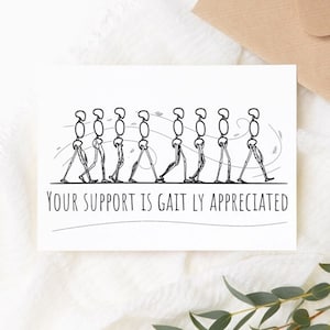 May include: A white card with a black and white illustration of a stick figure walking. The text "YOUR SUPPORT IS GAIT LY APPRECIATED" is printed below the illustration.