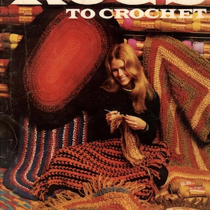 Può includere: Un libretto vintage di modelli di tappeti all'uncinetto con una donna che lavora a uncinetto un tappeto. La copertina presenta il titolo "Rugs to Crochet" e mostra diversi tappeti all'uncinetto colorati.