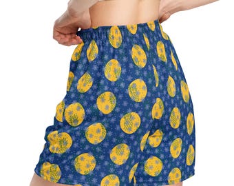 May include: Blue athletic shorts with a yellow pineapple pattern. The shorts have an elastic waistband and a relaxed fit.