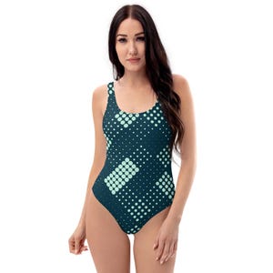 May include: A dark blue one-piece swimsuit with a geometric pattern of light green circles and squares.