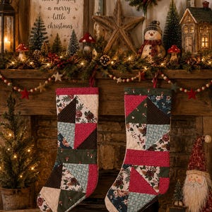 Könnte beinhalten: Zwei Patchwork-Weihnachtsstrümpfe mit verschiedenen Stoffmustern, darunter florale Drucke, unifarbenes Dunkelrosa und Dunkelgrün mit kleinen Pilzmotiven. Die Strümpfe sind aus dreieckigen und rechteckigen Stoffsegmenten zusammengesetzt.