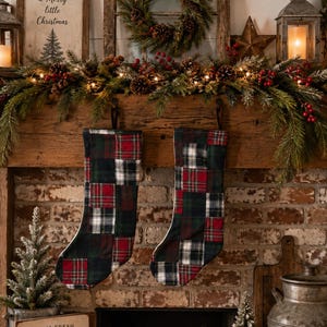 Könnte beinhalten: Zwei Weihnachtsstrümpfe aus einem Patchwork aus rot, grün und weiß kariertem Stoff. Die Strümpfe haben eine klassische Stiefelform mit einer Aufhängeschlaufe an der Oberseite und zeigen eine Vielzahl von Tartanmustern, die in einem Rasterdesign vernäht sind.