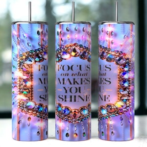May include: Three stainless steel tumblers with a purple background and a gold crown design. The tumblers have the text "FOCUS on what MAKES YOU SHINE" printed on them.