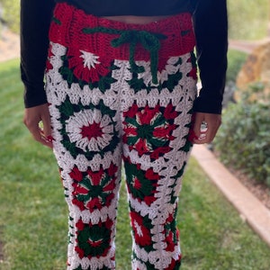 May include: Crocheted pants in red, white, and green with a floral pattern. The pants have a drawstring waist.