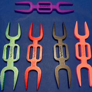 May include: Five plastic forks in different colours, each with a unique design. The forks are green, red, black, pink and purple. Each fork has the text "SpicyFork" printed on it.