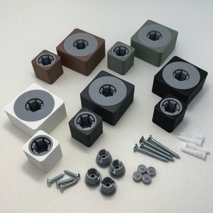 May include: Assortment of small, square, and round wall mounts in various colors, including gray, brown, and green. The mounts have a hole in the center and are designed for hanging items on a wall.  Also included are small screws, anchors, and other hardware.