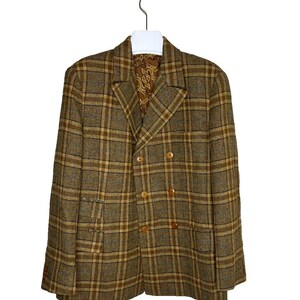 Puede incluir: Una chaqueta de traje de doble botonadura de cuadros marrones y beige con cuatro botones marrones.