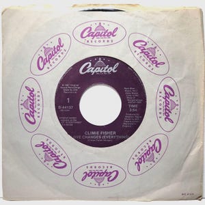 May include: A purple vinyl record with a white label. The label has the text "Capitol Records" in a circle around a capitol building. The record is titled "Love Changes (Everything)" by Climie Fisher. The record is from 1967 and has a time of 3:54.