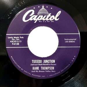May include: A purple vinyl record with a white label. The record is titled "Tuxedo Junction" by Hank Thompson and His Brazos Valley Boys. The record label also includes the song's publishing information, the record label, and the record number.